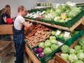 MINSK, BELARUS - MAY 22, 2019: Worker taking a vegetables in supermarket