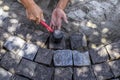 Worker taps granite stones with a rubber hammer, repairing the sidewalk, top view. The process of laying paving slabs in a circle Royalty Free Stock Photo