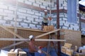 A worker throws bricks at another worker, construction work in a private area, wooden scaffolding near the walls Royalty Free Stock Photo
