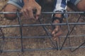 Worker ties wire metal steel to building structure at construction site. Man hand holding material Metal Steel reinforced rod for Royalty Free Stock Photo