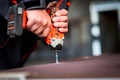 Worker tightens a screw with an electric screwdriver