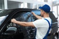 Worker tinting car window with foil