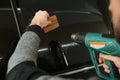 Worker tinting car window in shop