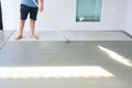 Worker to skim coat surface of concrete pavement floor or slab