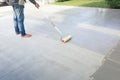 Worker to skim coat surface of concrete pavement floor or slab