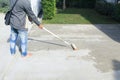 Worker to skim coat surface of concrete pavement floor or slab