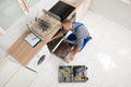 Worker With Toolbox Repairing Dishwasher Royalty Free Stock Photo