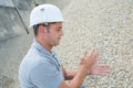 worker touching granite pebble