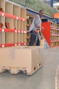 Worker transporting boxes on hand trolley