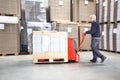 Worker Transporting Goods On Handtruck