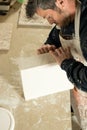 Worker Trying to Detach a Plaster Model from Mold