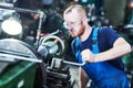 Worker turner operating lathe machine at industrial manufacturing factory