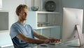 IT worker typing desktop computer in home office closeup. Remote workplace view