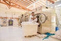 Worker in uniform cleaning bed sheets