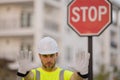 Worker in uniform gesturing stop. Serious builder with stop road sign. Builder with stop gesture, no hand, dangerous on