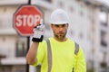 Worker in uniform gesturing stop. Serious worker with stop road sign. Builder with stop gesture, no hand, dangerous on