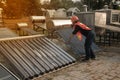 The worker in uniform and helmet checks concentrating Solar Power with Flat Plat collector and Evacuum Tube Collector.