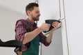 Worker in uniform installing roller window blind indoors Royalty Free Stock Photo