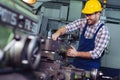 Worker in uniform operating in manual lathe in metal industry factory. Royalty Free Stock Photo