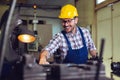 Worker in uniform operating in manual lathe in metal industry factory. Royalty Free Stock Photo