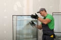 Worker in uniform preparing double glazing window for installation indoors Royalty Free Stock Photo