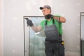 Worker in uniform preparing double glazing window for installation indoors Royalty Free Stock Photo