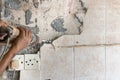 Worker use demolition hammer drill to break up tiles from wall surface. Motion blur intended.