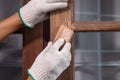 Worker use sandpaper removing the old surface of wooden window before apply wood preserver