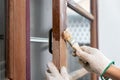 Worker use sandpaper removing the old surface of wooden window before apply wood preserver. Royalty Free Stock Photo