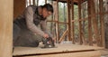 A worker uses a circular saw to cut plywood