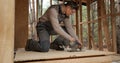 A worker uses a circular saw to cut plywood
