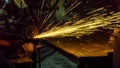 worker uses cutting machine to cut metal, focus on flash lig Royalty Free Stock Photo