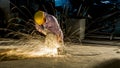 worker uses grinding cut metal, focus on flash light line of sharp spark,in low light Royalty Free Stock Photo