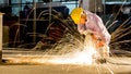 worker uses grinding cut metal, focus on flash light line of sharp spark,in low light Royalty Free Stock Photo