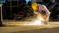 worker uses grinding cut metal, focus on flash light line of sharp spark,in low light Royalty Free Stock Photo