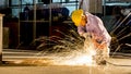 worker uses grinding cut metal, focus on flash light line of sharp spark,in low light Royalty Free Stock Photo