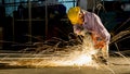 Worker uses grinding cut metal, focus on flash light line of sharp spark,in low light Royalty Free Stock Photo