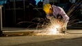 worker uses grinding cut metal, focus on flash light line of sharp spark,in low light Royalty Free Stock Photo