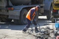 A worker uses a jackhammer to dismantle a drainage grate on a city street. May 29, 2020, Russia, Magnitogorsk