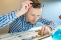 worker uses magnifying glass at printer