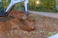 Worker uses tractor to excavate ditch for laying drainage conduit