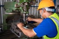 A worker uses a vernier measuring machine to inspect components for fabrication on a lathe at a factory. Selective focus of lathe