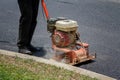 Worker uses vibratory compactor compacting asphalt at road repair Royalty Free Stock Photo