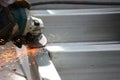 Worker using angle grinder polishing steel structure with yellow sparks Royalty Free Stock Photo