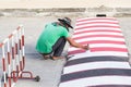 Worker using brush for painting white line on the road Royalty Free Stock Photo