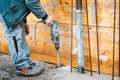 Worker using a drilling power tool on construction site and creating holes in concrete Royalty Free Stock Photo