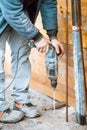 Worker using a rotary power tool on construction site and creating holes in concrete Royalty Free Stock Photo