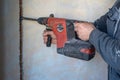 Worker using a jackhammer to drill into wall for electricity installation, on construction site Royalty Free Stock Photo