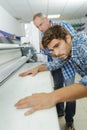 Worker using large format ink jet printer Royalty Free Stock Photo