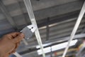 Worker is using locking keys to lock top cross rails to furring channels in concealed ceiling Royalty Free Stock Photo